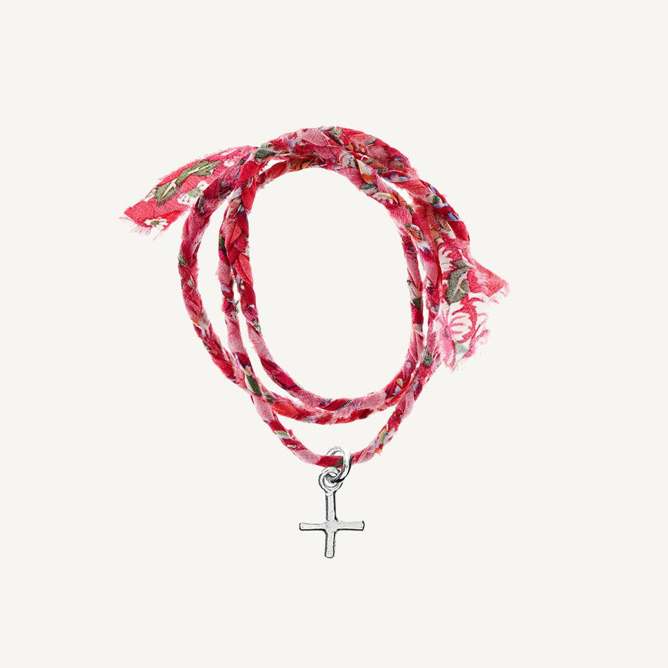 A floral patterned Liberty Wrap bracelet with a silver cross pendant.