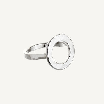 A simple silver ring with a large circular design on the top part, against a white background.