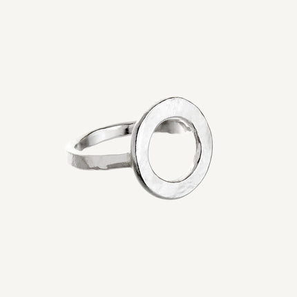 A simple silver ring with a large circular design on the top part, against a white background.