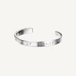 A silver bangle bracelet with the inscription 'You are my sunshine' stamped on it.